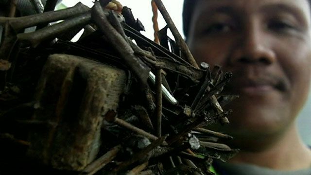 Man holding nails collected from the street in Jakarta, Indonesia