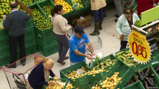 Clientes escogen mercadería en un mercado de frutas y verduras de Brasil.