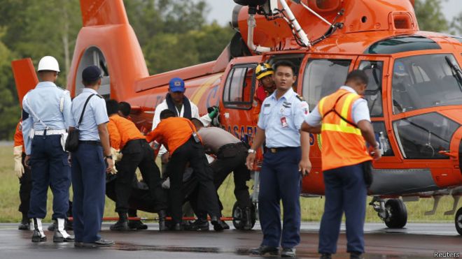 Equipe transporta corpo de passageiro do voo QZ8501 (foto: Reuters)