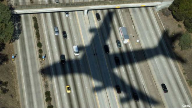 La sombra de un avión sobre una calle citadina
