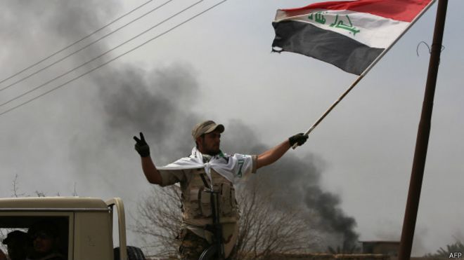 Uno de los militares iraquíes hace la señal de la victoria después de recuperar una ciudad cerca de Tikrit.