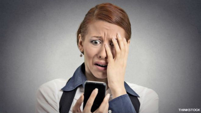 Una ejecutiva horrorizada ante lo que lee en su teléfono inteligente