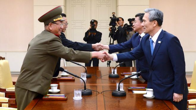 朝鮮代表黃炳誓（左一）、金養建（左二）與韓國代表金寬鎮（右一）、洪容杓（右二）在會談期間握手（22/8/2015）