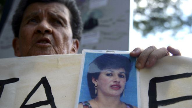 Durante una manifestación, una mujer sostiene una foto de una desaparecida.