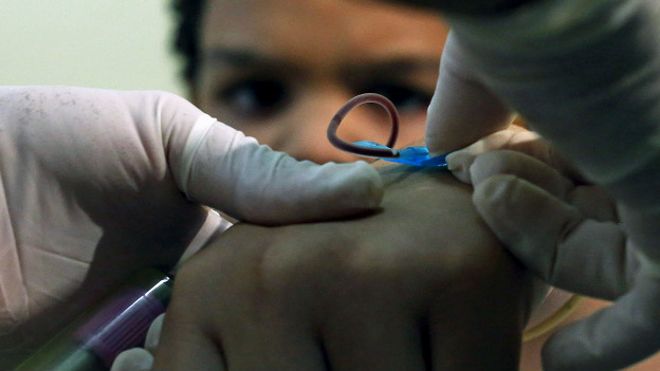 Un trabajador de salud en la ciudad brasileña de Sao Paulo toma una muestra de sangre a un niño para determinar mediante un test si está infectado con zika, dengue o chicungunya.