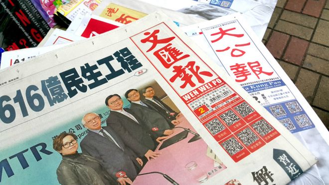 香港中环某报摊上发售的《文汇报》（左）与《大公报》（右）（BBC中文网图片2/2/2016）