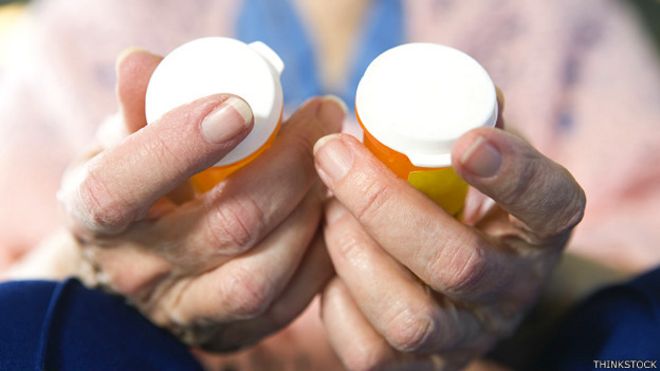 Mujer con frascos de medicamentos en la mano