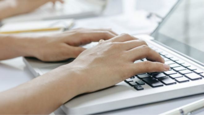 يد تنقر لوحة مفاتيح كمبيوتر