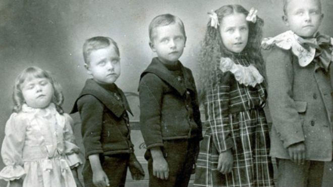 Fotografía de varios niños con una hermanita muerta.