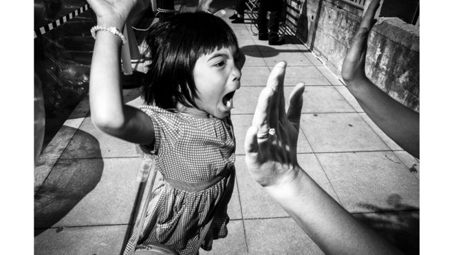 طفل يرفع يده تعبيرا عن النجاح في بيالوما، الولايات المتحدة. تود بيشوف