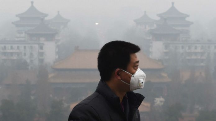 12月初首次空氣汙染紅色預警期間戴上口罩的北京市民