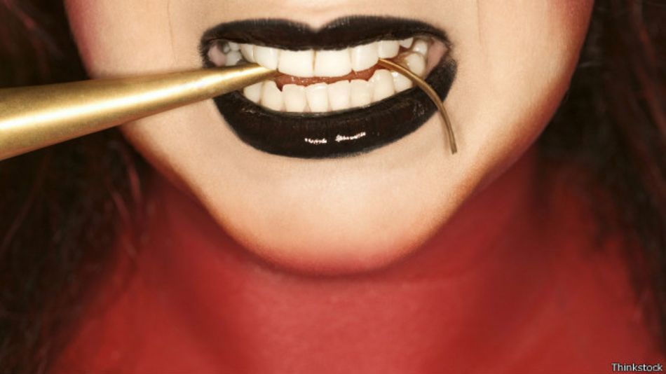 Labios de mujer con un objeto en la boca.