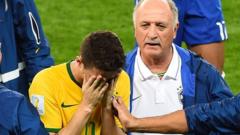 Scolari consoles midfielder Oscar on the final whistle