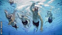 David Williams with three young people swimming in a ppl