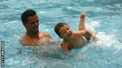 man and his boy in a swimming pool