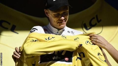 Chris Froome puts on the yellow jersey he reclaimed at the end of stage 14