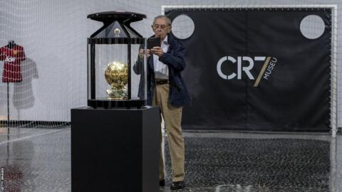 A visitor takes a photo of the Ballon D'Or at the Cristiano Ronaldo museum in Madeira