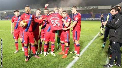Rochdale players hold a shirt in support of ill five-year-old Joshua McCormack