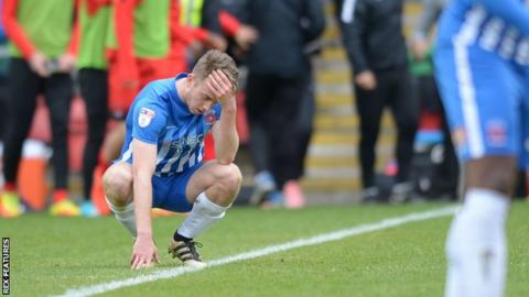 Hartlepool's Rhys Oates sits dejected on the turf