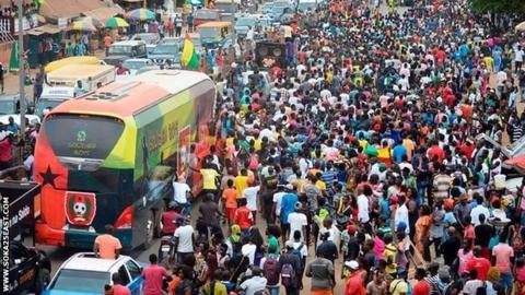 Guinea-Bissau's team coach travels through the crowds