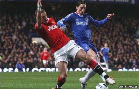 Manchester United's Nemanja Vidic tangles with Fernando Torres