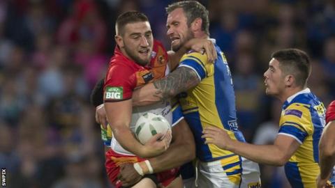 Catalan's Julian Bousquet (left) is held up by Jamie Peacock of Leeds.