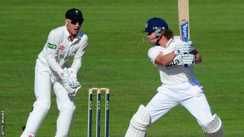 Hamish Marshall of Gloucestershire plays a shot as Mark Wallace of Glamorgan shouts instructions to his side's fielders.