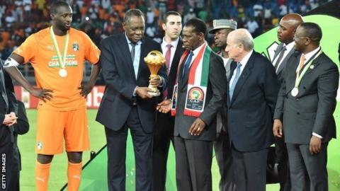 Yaya Toure wait to be handed the trophy, with Caf president Issa Hayatou to his right