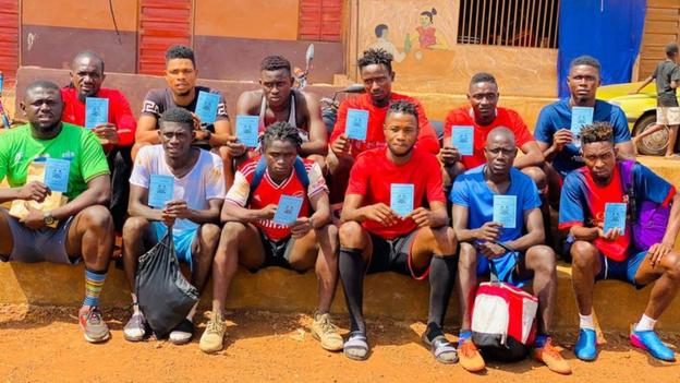Players from Sierra Leone's Anti-Drugs Strikers FC with their Covid-19 vaccination cards