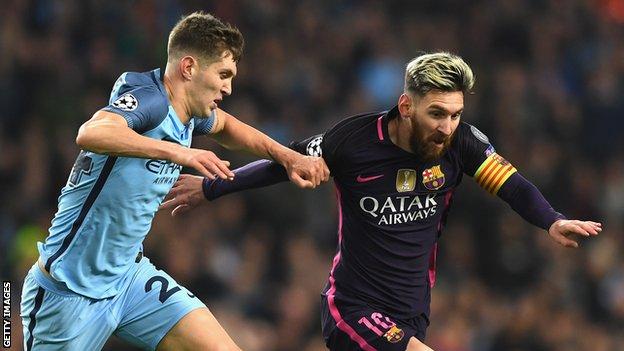 John Stones battles with Barcelona forward Lionel Messi