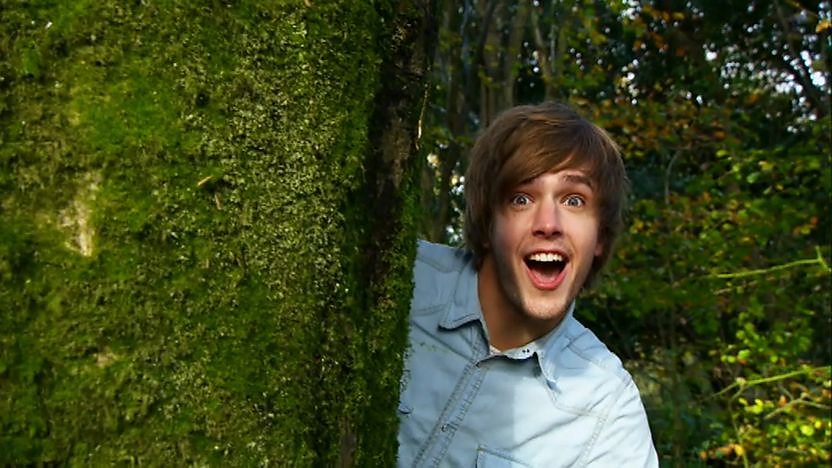 Iain Stirling next to a hedge