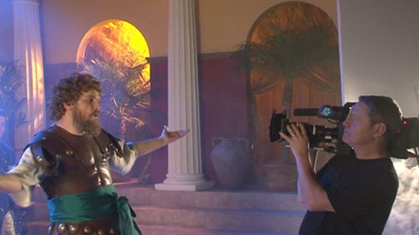 Horrible Histories star Jim sings into a camera held by a camera man