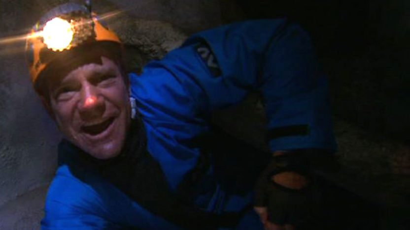 Steve Backshall wriggling through a very narrow cave
