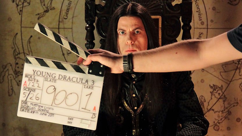 Count Dracula with a clapper board in front of his face.