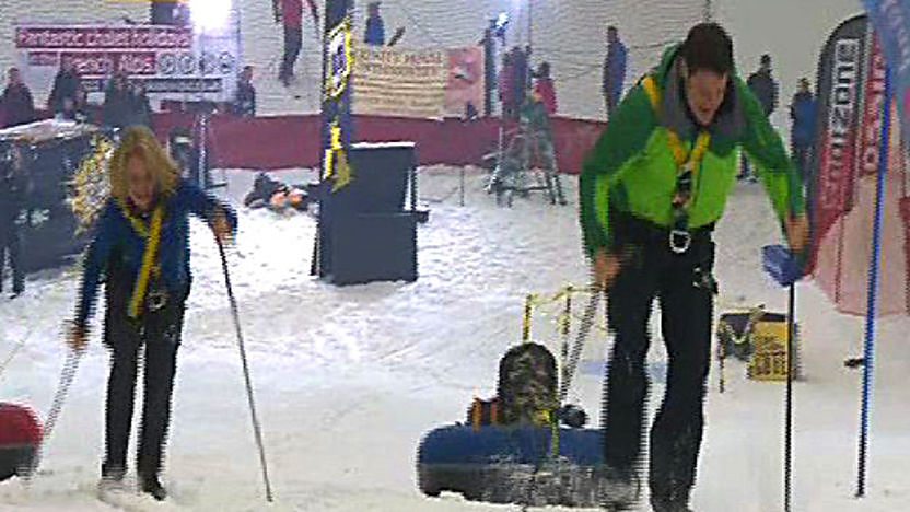 Steve Backshall racing Ann Daniels up a snow slope on skis