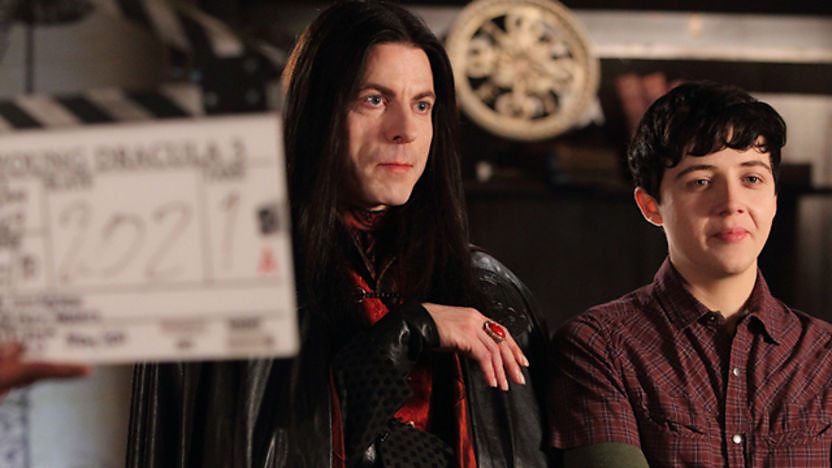 Vlad and the Count behind a clapper board.