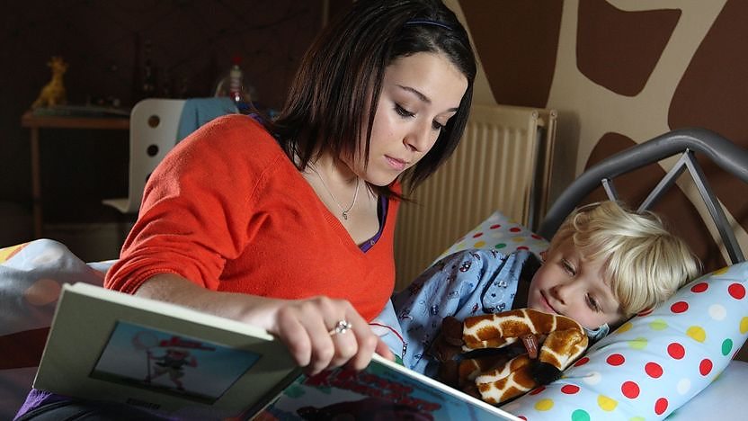 tracy reading to young child in bed