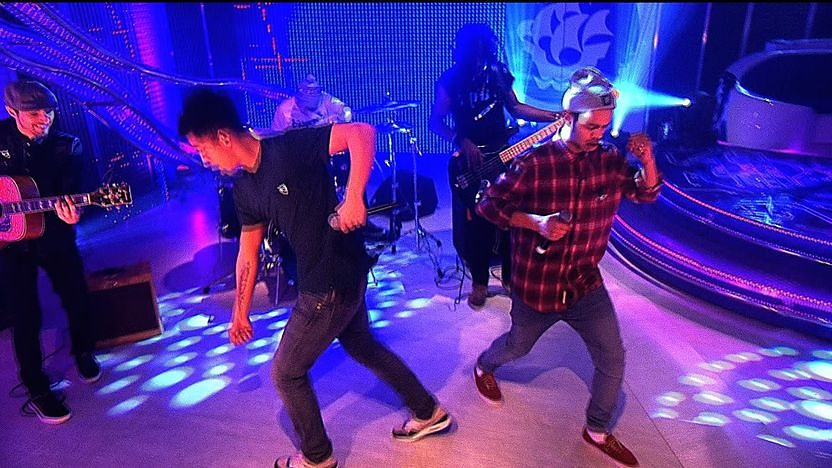 Rizzle kicks dancing in the Blue Peter studio with their band in the background.