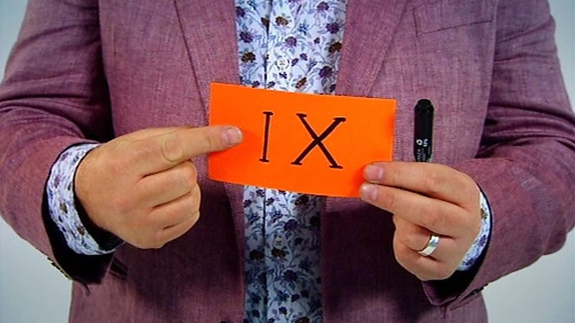 A card with IX on it being held.