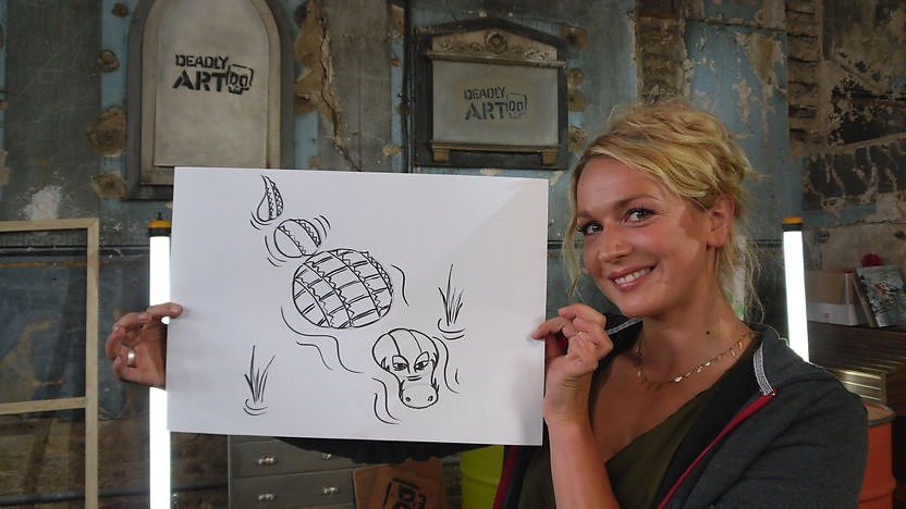 Nicola holding a drawing of a crocodile.