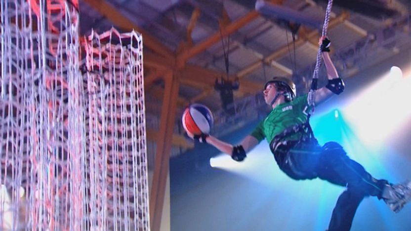 A contestant dunking a basketball into a net.