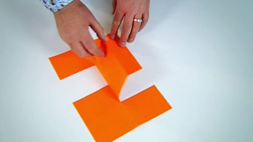 An impossible shape made from orange paper.