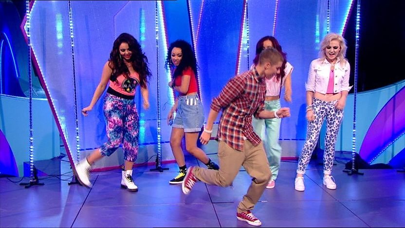Aidan Davis and Little Mix dancing on stage.