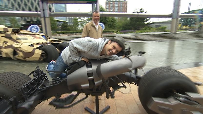 Barney Harwood sitting on the Batpod motorbike from The Dark Knight Rises