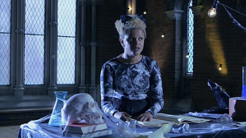 Gemma Cairney in front of a big window reading a book