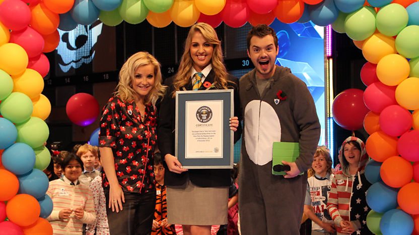 Helen, Barney and a representative from Guinness World Records in front of some balloons.