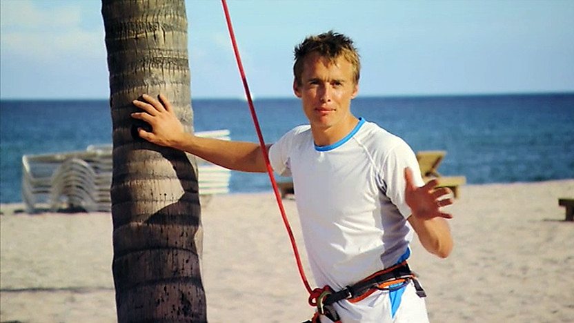 Leo with a harness, ready to climb a palm tree.