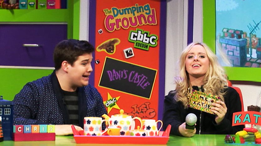 Chris Johnson and Katie Thistleton in the CBBC Office, Katie is wearing a gold chain with 'MC Katie' round her neck.