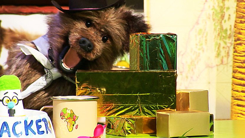 Hacker T Dog smiling next to a pile of gold bars