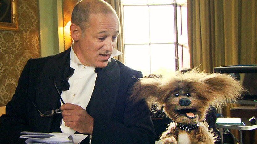 Mike Milligan from the Dumping Ground dressed up in a tuxedo next to Dodge T Dog from the CBBC Office.